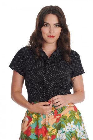 Blouse noire à pois style pin-up inspiration 1950's Matière fluide légère et agréable à porter Col lavalière à nouer Manches courtes Fermeture avec boutons et boutonnières Pinces sur le bas du chemisier Longueur sous la taille